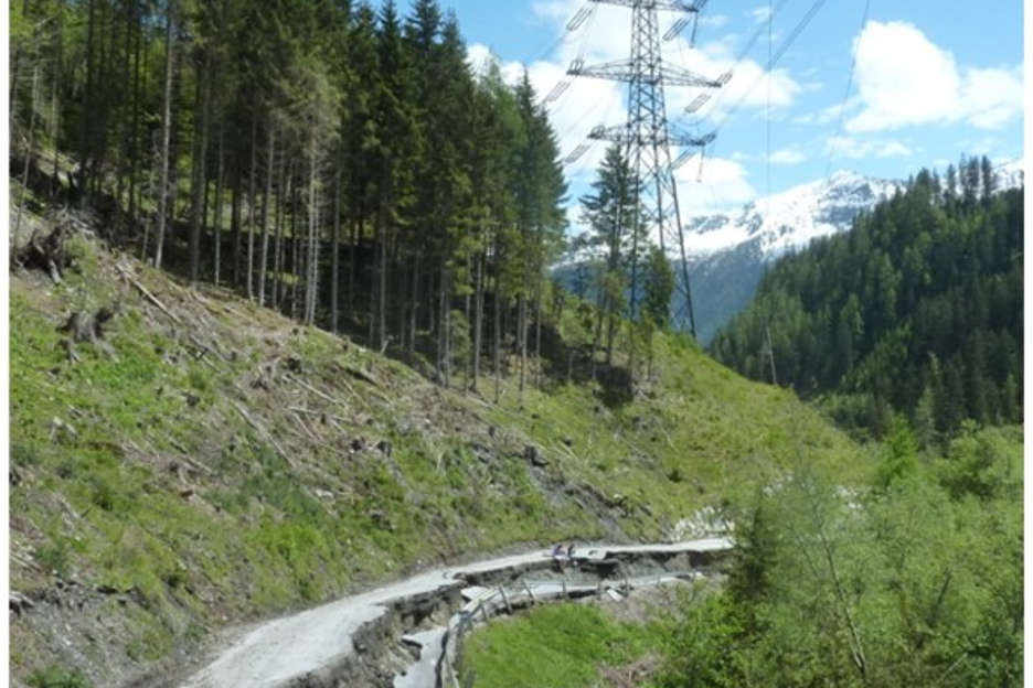 Mudslide and a damaged road below a power line