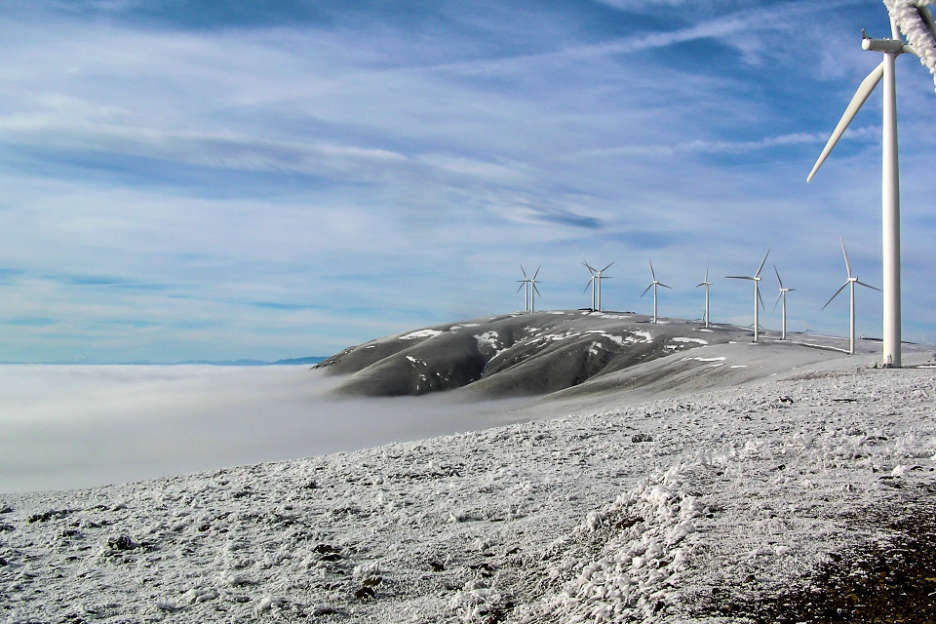 Icy mountain ridge with a wind farm installation